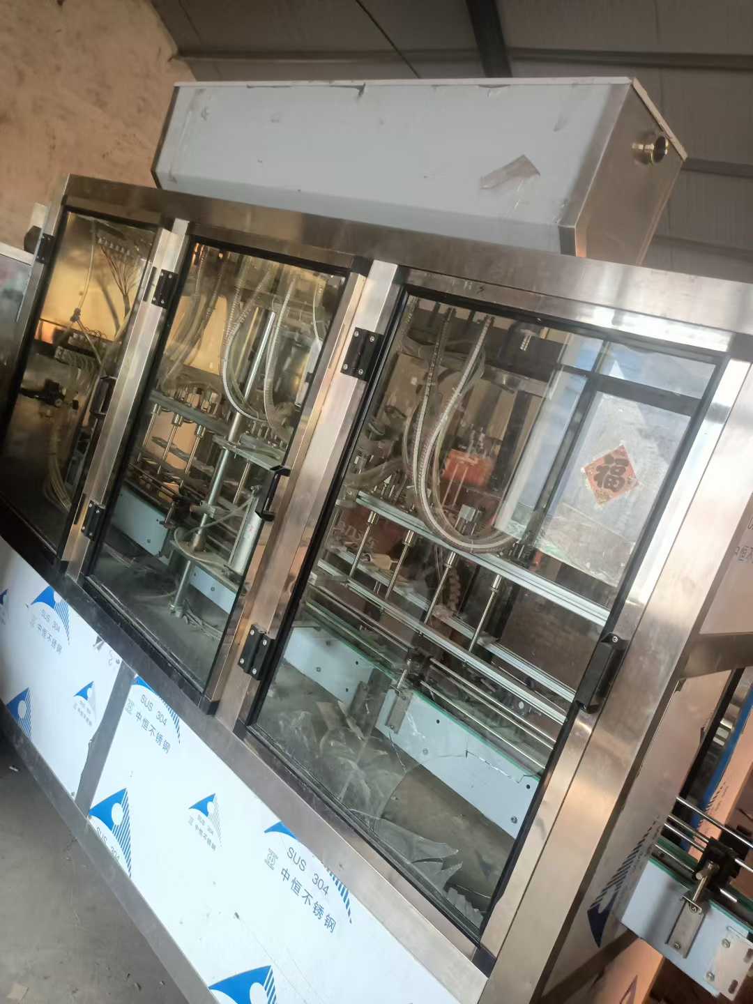 Brand new, undeployed 12-head linear liquid filling machine.