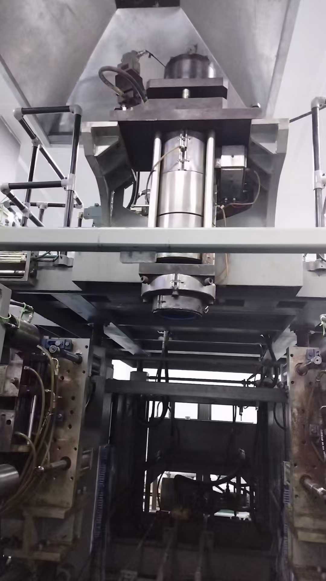 The 2020 Uni-100 DC dual-station machine, MOOG Generation 3+ with no rod locking mechanism, bottom blowing, and a robotic arm; can produce barrels up to 30L in size.